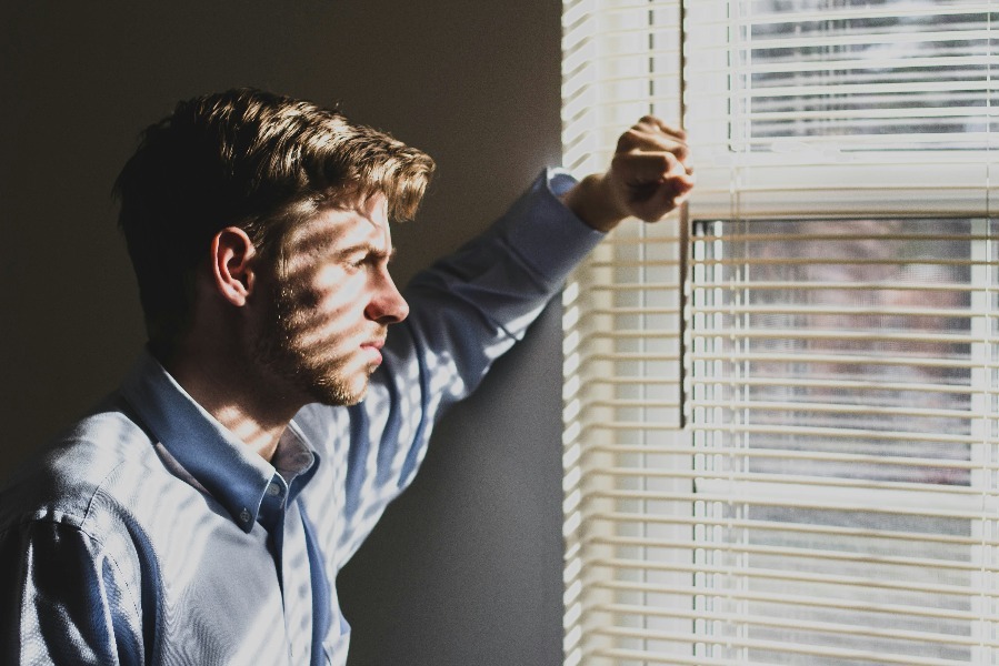 Nachdenklicher Mensch am Fenster, Sinnbild für innere Beweglichkeit in Zeiten des Wandels.
