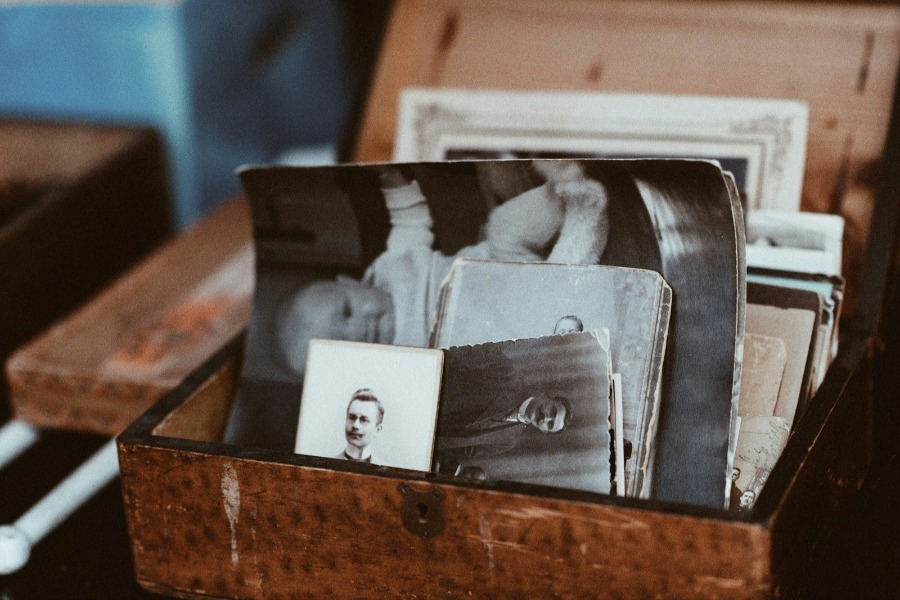 Box mit alten Familienfotos. Familienaufstellungen machen Dynamiken in Familien sichtbar.