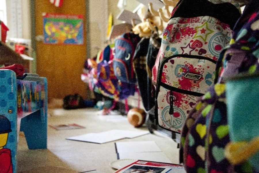 Kinder tragen stolz ihren Schulranzen, Sinnbild für einen bewusst begangenen Übergang.