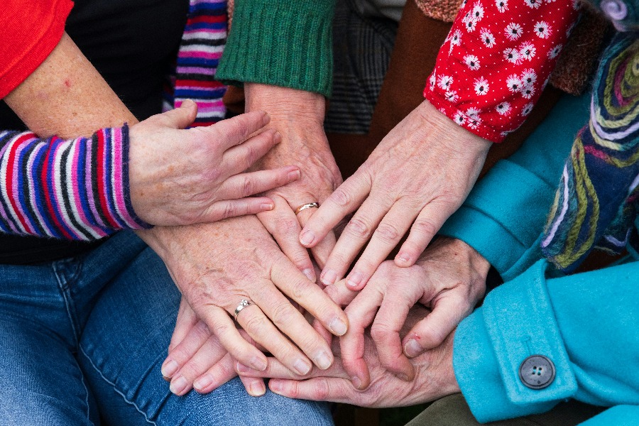 Hände von Frauen verschiedener Generationen übereinandergelegt, Sinnbild für die weibliche Ahnenlinie.