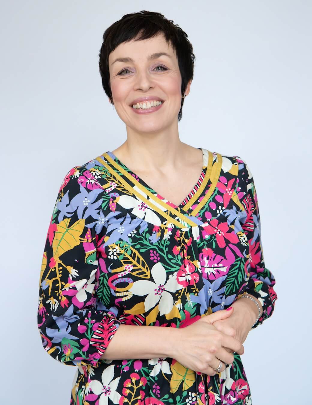 Katja Fesselmann in einem Blumenkleid mit kurzen Haaren